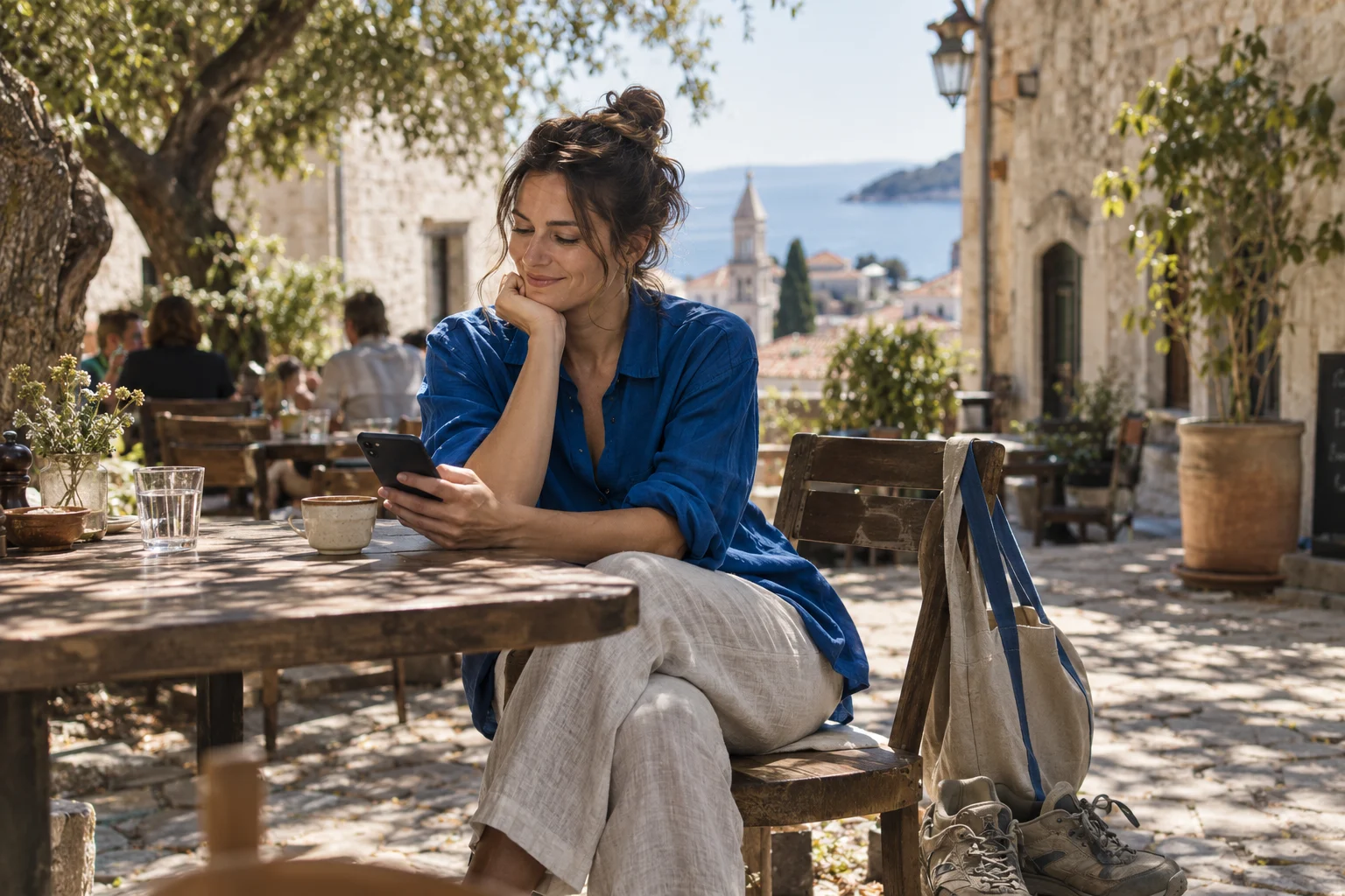 A relaxed afternoon at a sunlit café, with time to check the opportunities on a phone.